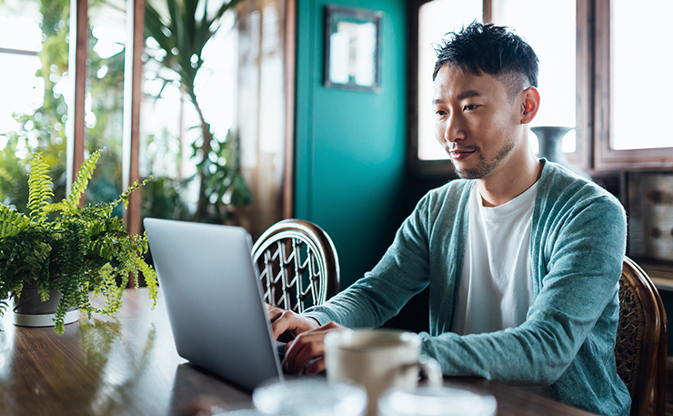 Young man on a laptop in a home office.