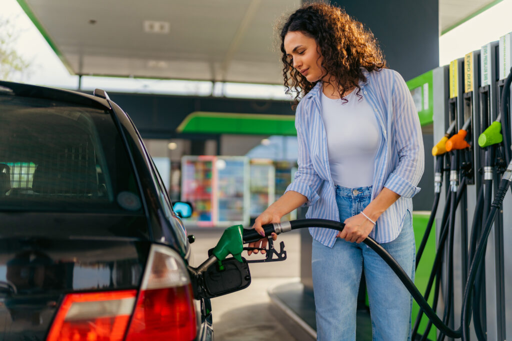Woman filling up care with gas at gas pump