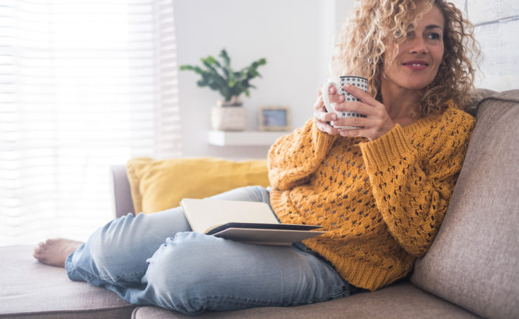 Woman sitting on couch with coffee